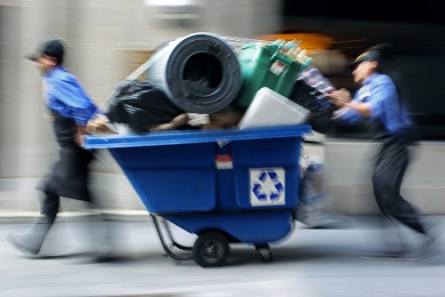 Workers loading construction waste into a bulky skip in Hendon.